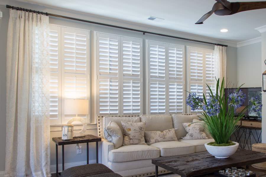 White Polywood shutters on windows behind a white sofa